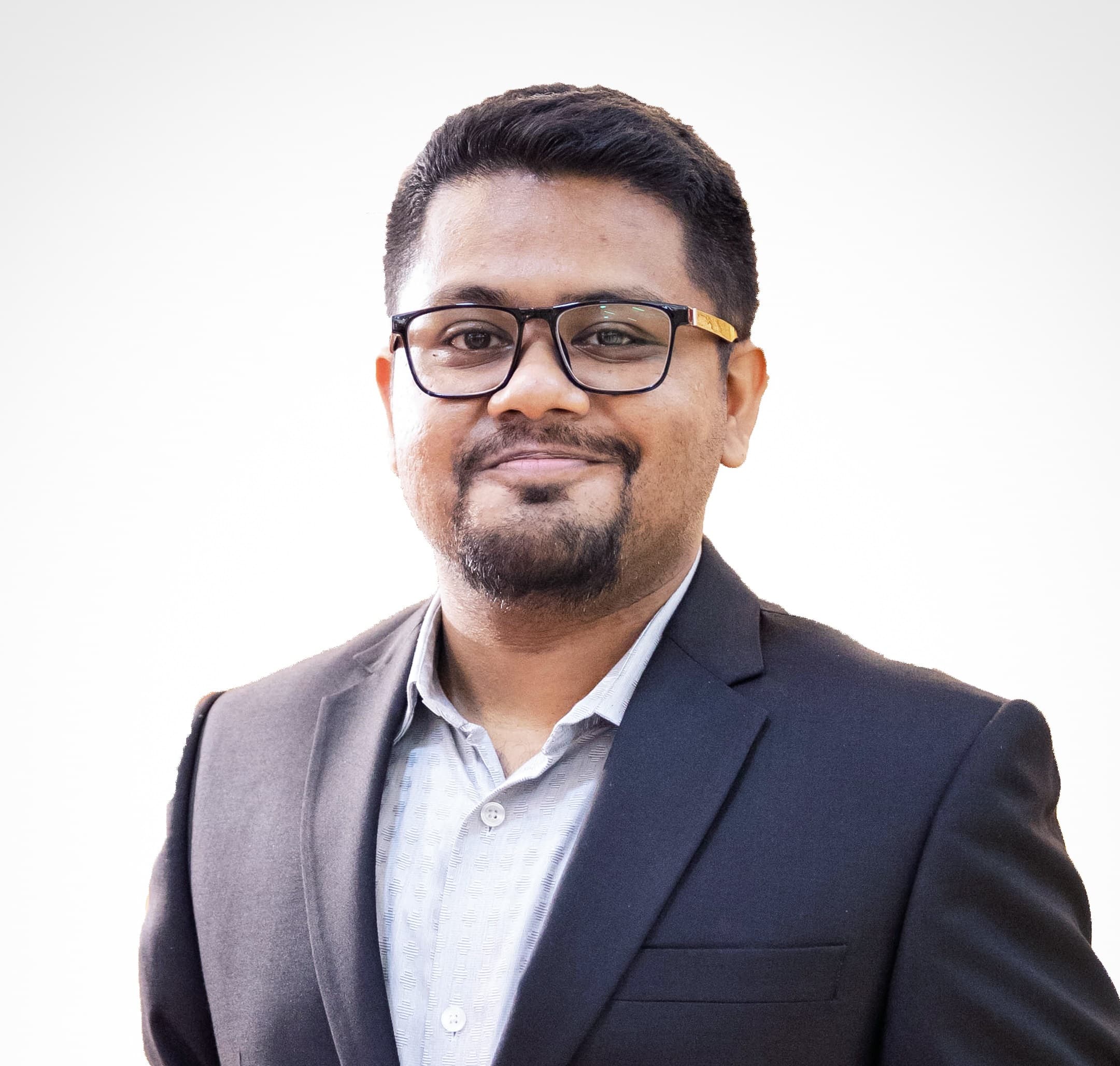 J S Mahboob wearing a dark suit and glasses