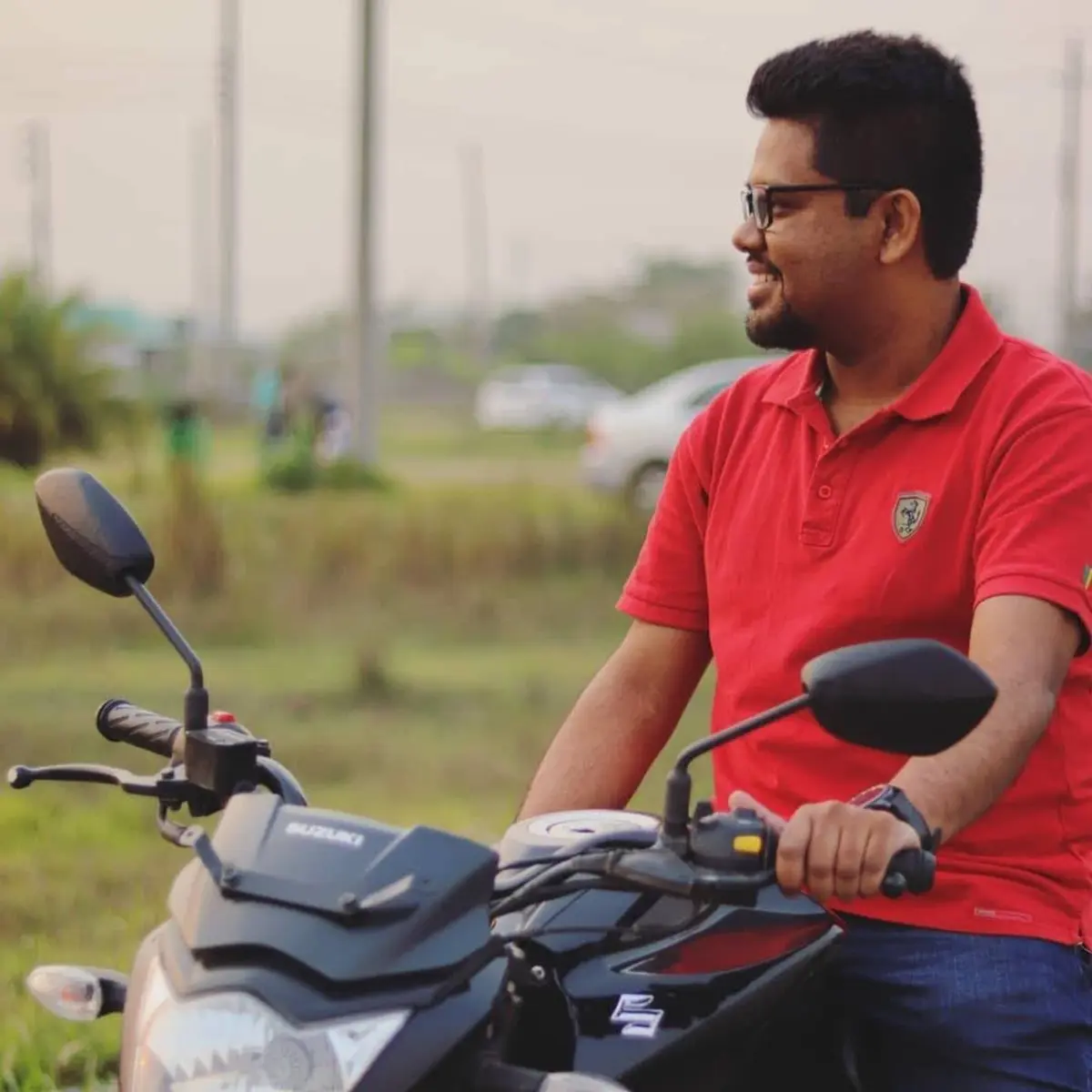J S Mahboob seated on a motorcycle in an open field